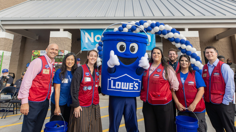 Lowe's employees in front of the store, with the company's signature bucket mascot in the middle.