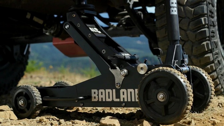 The Badland off-road jack from Harbor Freight supporting a lifted vehicle.