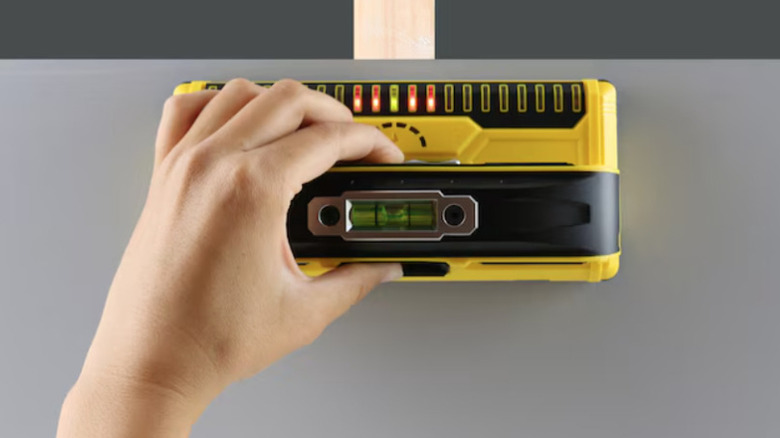 Franklin Sensors stud finder in action with LED lights indicating center of stud
