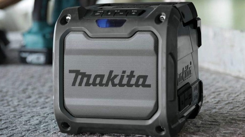 A Makita Bluetooth speaker on a floor.