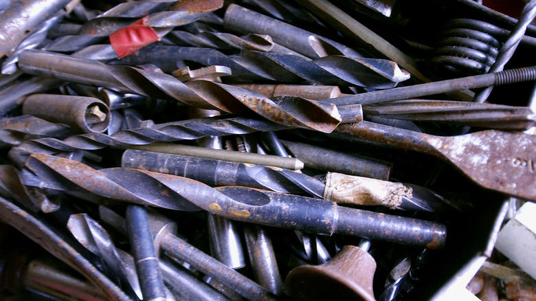 A box full of old rusted drill bits and miscellaneous parts
