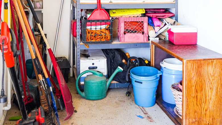 A cluttered shelf in a garage.