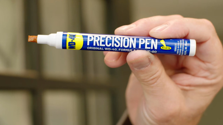 A hand holding the WD-40 Precision Pen