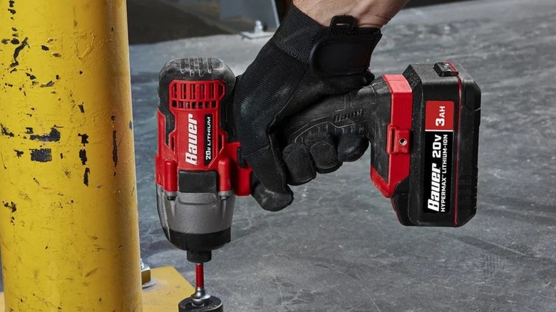 A person using a Bauer 20-volt impact driver