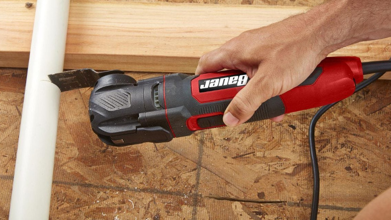 A corded Bauer multitool used to cut a plastic tube.