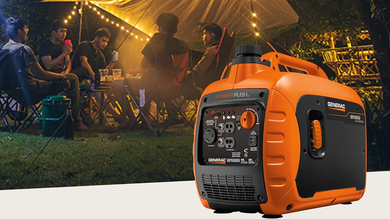 Generac gas-powered generator in orange next to a group of people at an outdoor campsite