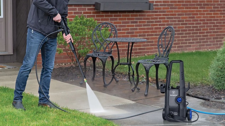 man using Westinghouse ePX3030 Pressure Washer on sidewalk