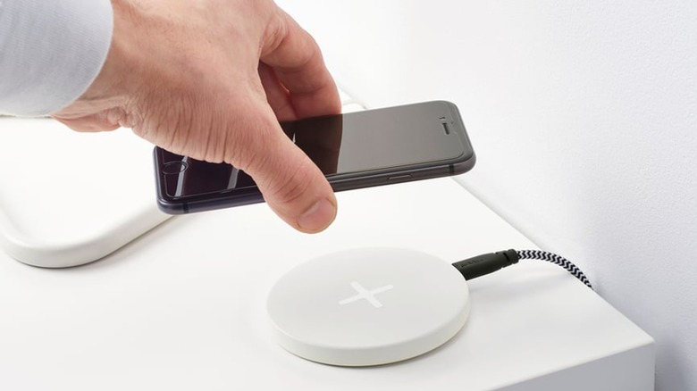 Hand placing phone on charging pad