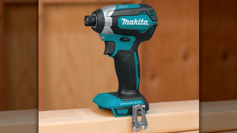 A Makita 18V impact driver on a wood beam.