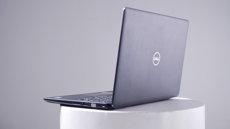 A Dell laptop placed on a white stand against a white background