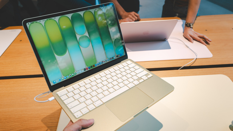 Person holding the MacBook Neo in a store