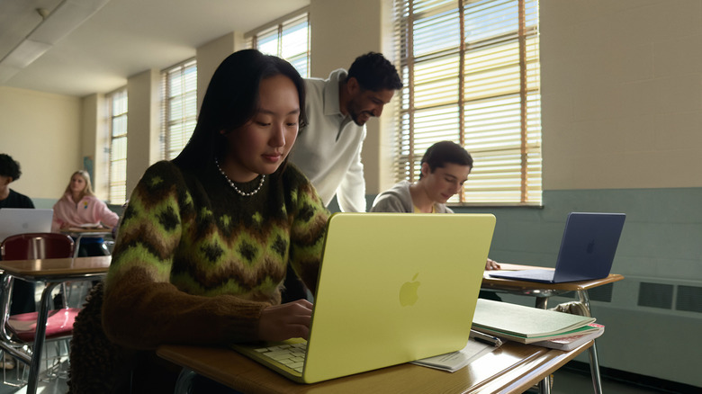 Woman using a yellow MacBook Neo