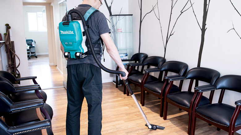 person using Makita backpack vacuum