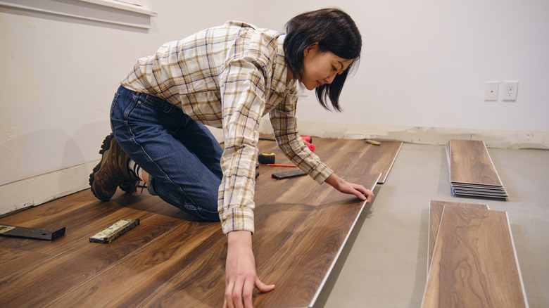 Woman installing laminate flooring