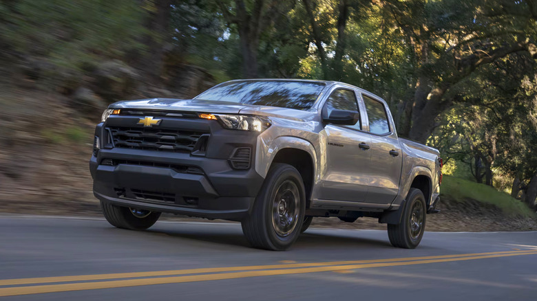 A silver 2026 Chevrolet Colorado driving on a country road