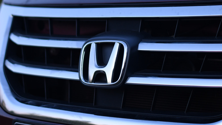 Close-up of a silver Honda logo on the front of a car