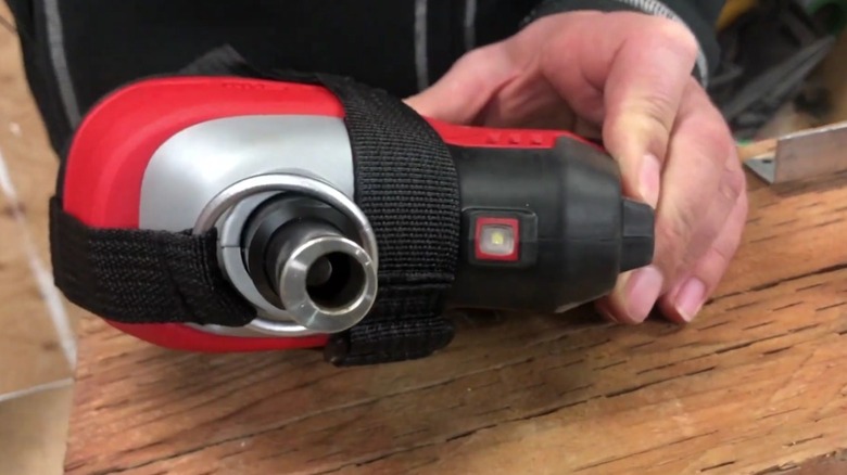 Person holds Milwaukee M12 Cordless Palm Nailer.
