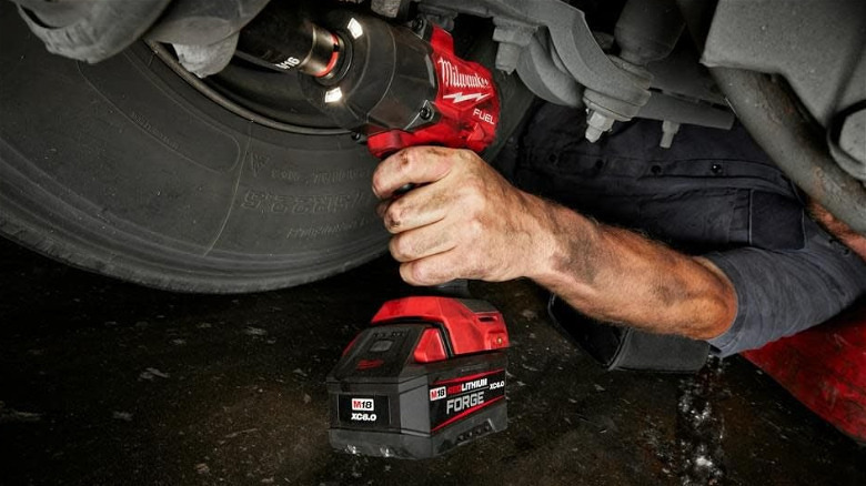 A Milwaukee High-Torque Impact Wrench used on the underside of a car.