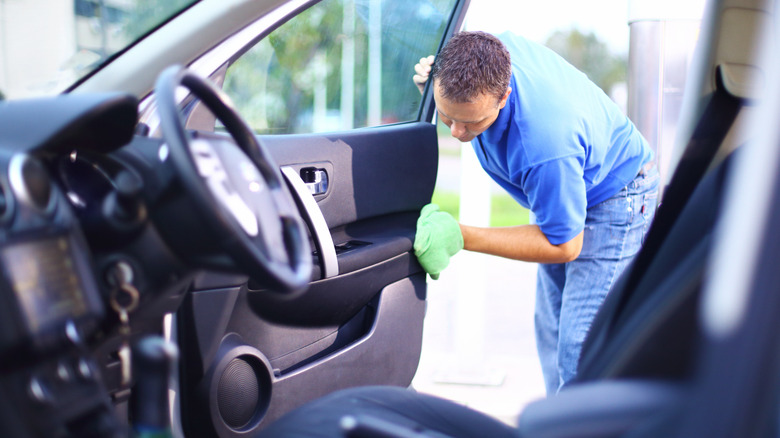 A Man Cleaning The Inside Of A Car