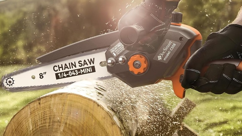 A person using a DocSmart mini chainsaw on a log.