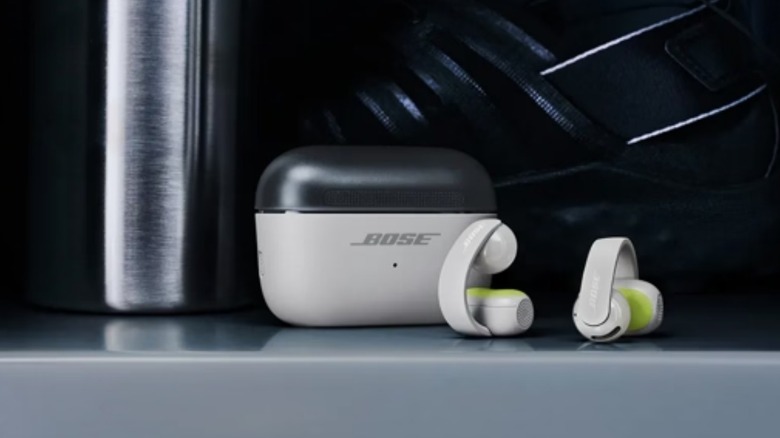 Bose earbuds beside their carrying case.