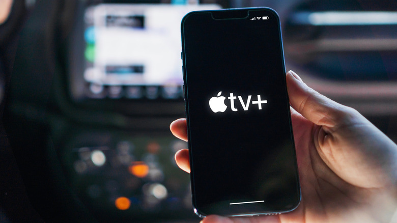 Person using Apple TV on an iPhone inside a car
