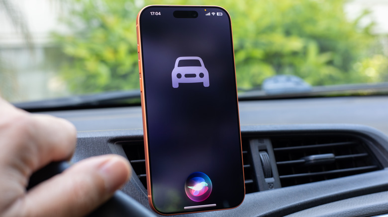 Person using Siri on an iPhone inside a car