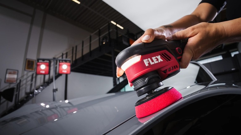 Close-up of a person using a Flex polisher on a vehicle.