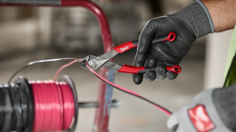A person cutting wire with pliers.