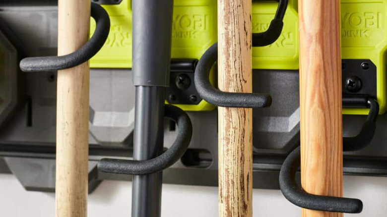 Four Ryobi Link Reversible S Hook holding wooden tools against a Ryobi Link Rail.