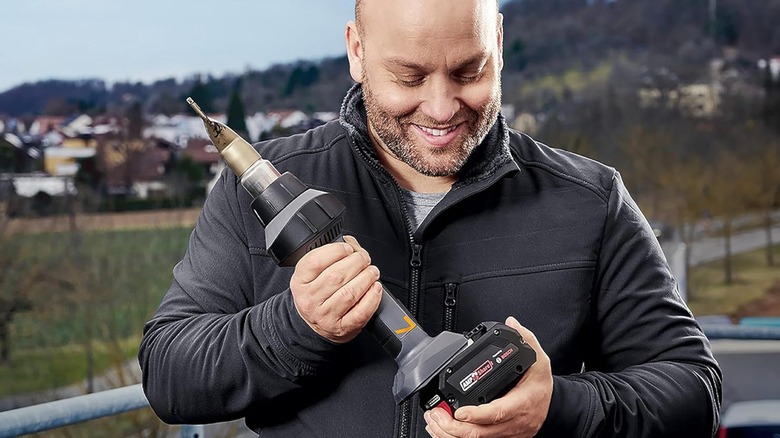 Person attaching battery to Steinel MobileHeat MH 7 Cordless Heat Gun