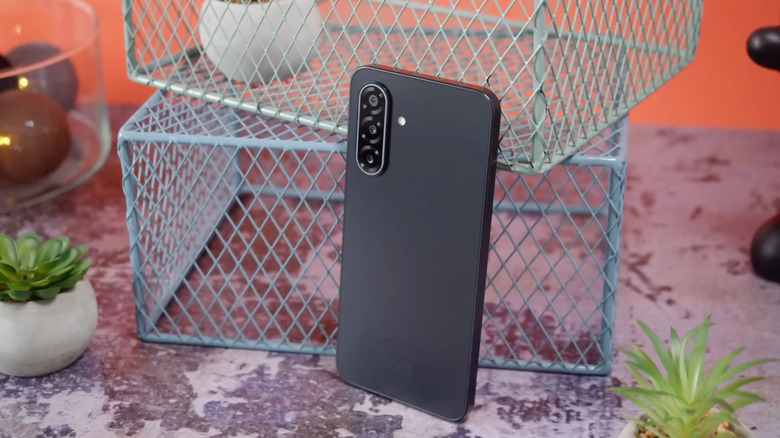 The Samsung Galaxy A17 5G next to some plant pots and metal crates, black colorway