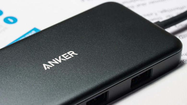 Close-up of a black Anker charging station on top of white paper with blurry text