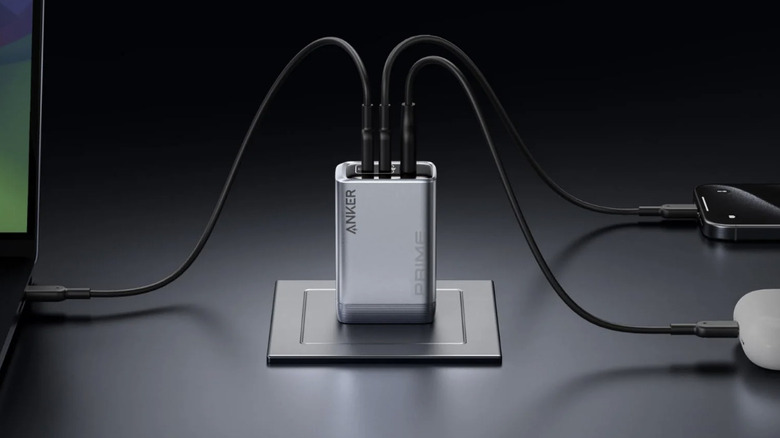 Close-up of an Anker wall charger plugged into three devices, including a laptop and a smart phone