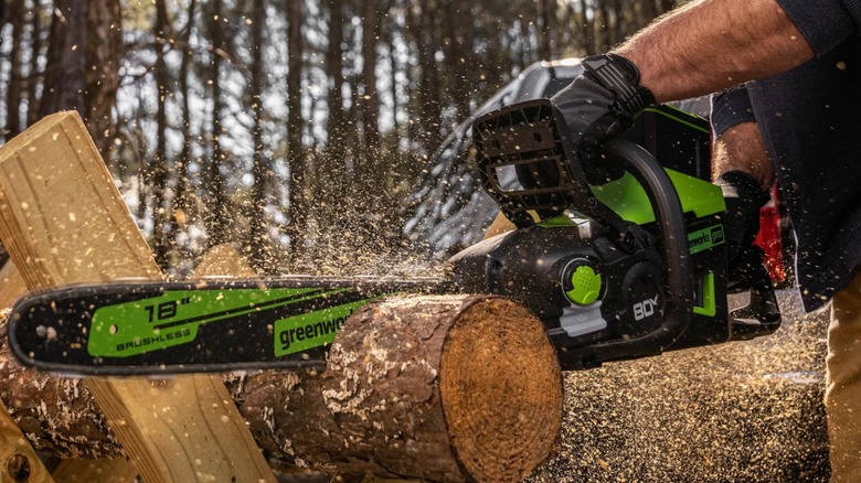 a person using a greenworks 80-volt 18-inch chainsaw