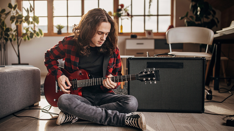 person playing red electric guitar