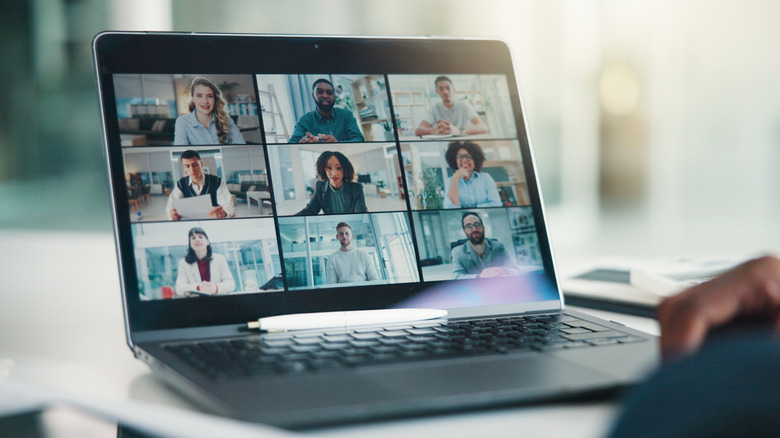 A laptop displaying nine people in a grid during a video call.