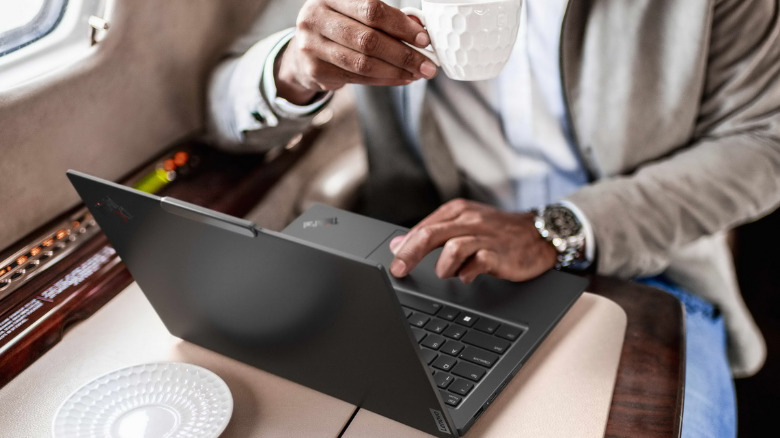 A person using Lenovo Thinkpad X1 Carbon Gen 12 on a train.
