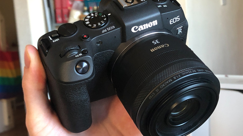 someone holding a Canon EOS RP camera with a 35mm lens