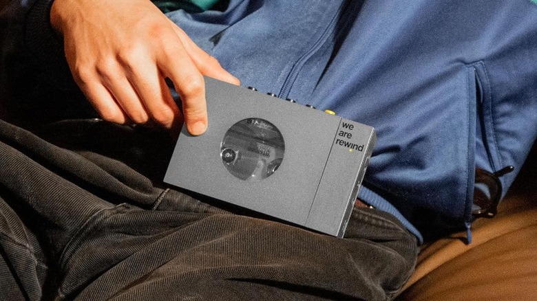 Person holding a Gray We Are Rewind Cassette Player resting in their lap