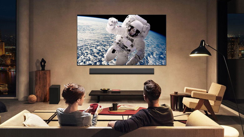 Couple watching a space walk on an OLED television