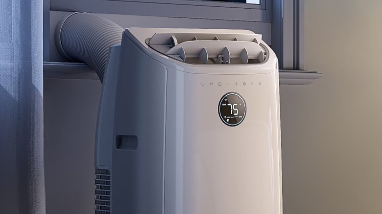 A Dreo air conditioner set up by a window.