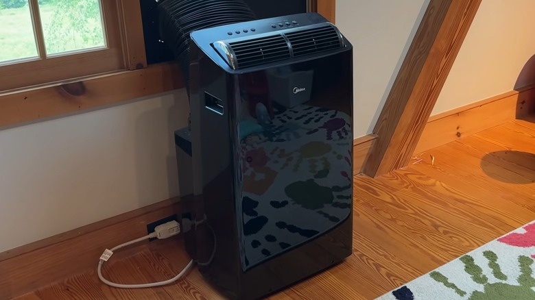 A Midea portable air conditioner connected to a window.