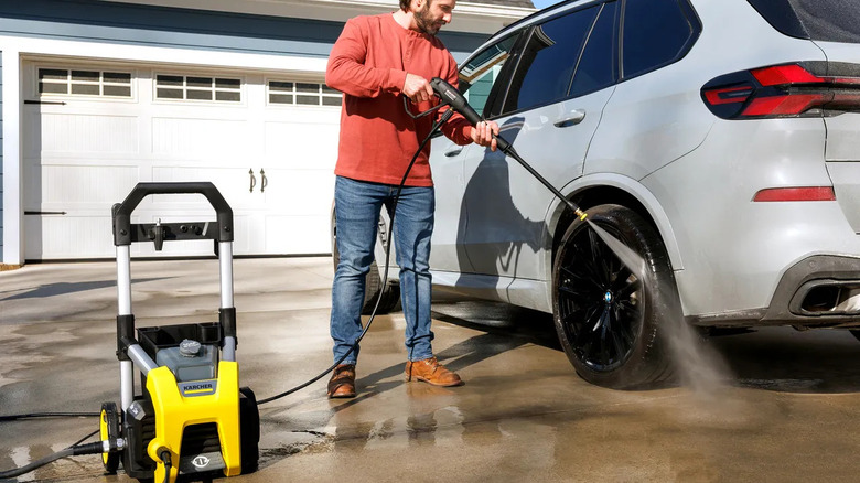 Car owner power spraying wheels of his car