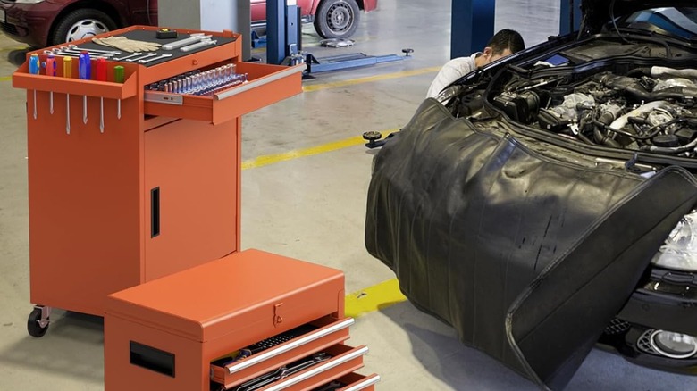 orange Goplus rolling tool chest next to car