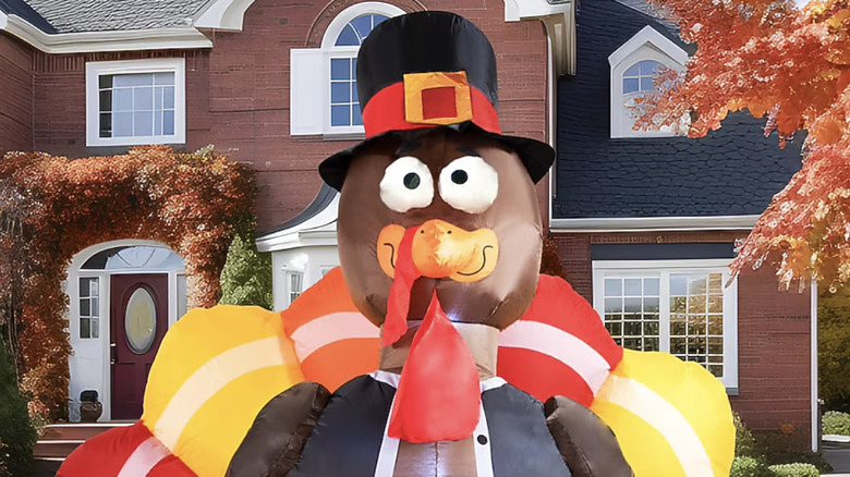 Close-up of a large inflatable turkey in front of a red brick home