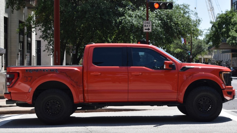 A red Ford F-150 Raptor entering an intersection