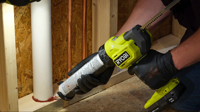 person using ryobi adhesive gun