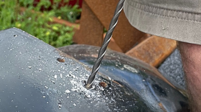 A person using a Bad Dogg drill bit in metal.