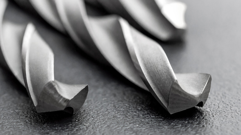 Three drill bits on a black surface.
